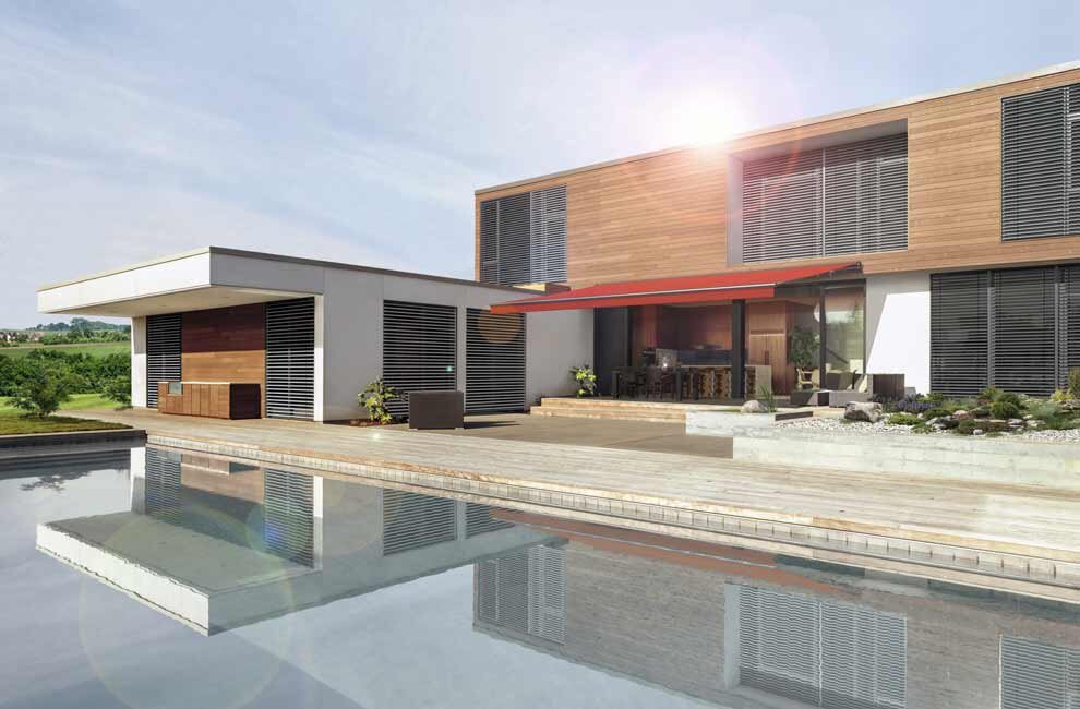 Rote Markise an modernem Haus mit Pool