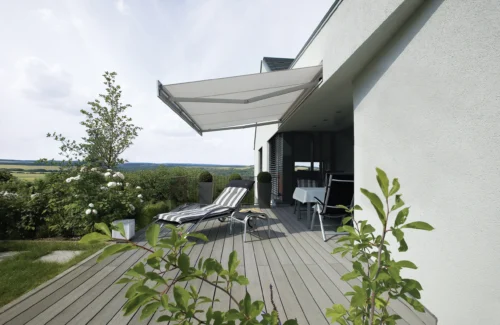 Moderne Terrasse mit Sonnenschutz und Liegestühlen